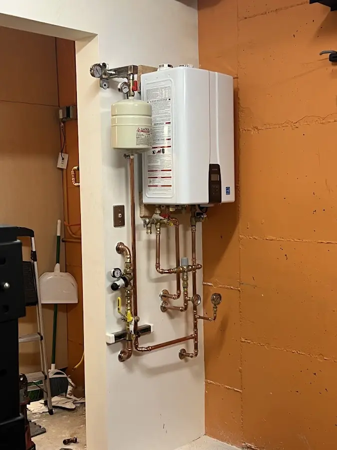 Plumbing technician inspecting water heater connections in Spring Ridge